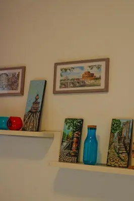 a shelf with vases and pictures on a wall at Alfieri home holiday in Rome