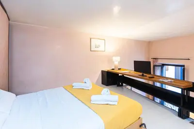 a bedroom with a desk and a bed with towels at Rental in Rome Navona Loft in Rome