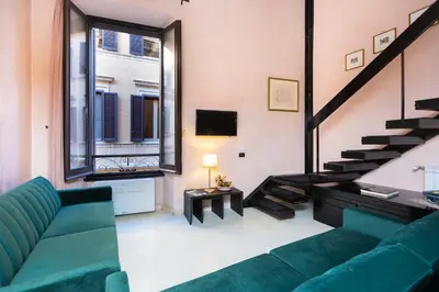 a living room with a green couch and a staircase at Rental in Rome Navona Loft in Rome