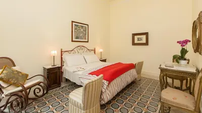 a bedroom with a bed and a chair and a table at Rental in Rome Ghetto Garden in Rome