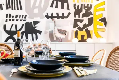 a table with plates and glasses and a bottle of wine at Villa Michelangelo Deluxe in Rome