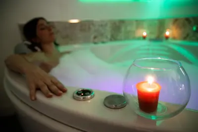 a woman is in a bath tub with a candle at Vatican Relais Rome in Rome