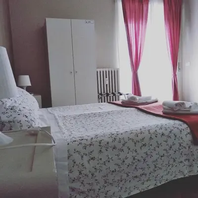a bedroom with a bed with a flowered blanket and a window at My Sweet Rome Guest House in Rome