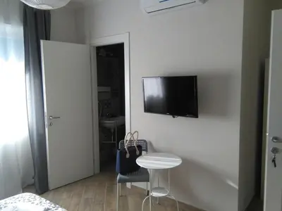 a room with a table and a tv on a wall at My Sweet Rome Guest House in Rome