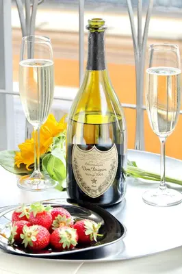 a bottle of wine sitting on a table with a plate of strawberries at Pantheon - Argentina Luxury in Rome