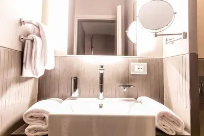 a bathroom with a white tub and a mirror at Orazio Palace Hotel in Rome