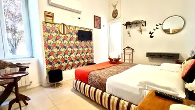a bedroom with a bed and a table and a window at Festina Lente in Rome