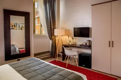a hotel room with a bed and a desk with a computer at Palazzo Medusa in Rome