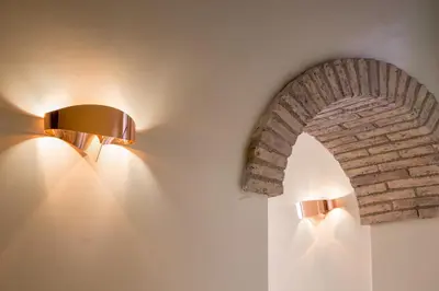 two lights on a wall with a brick arch at Palazzo Medusa in Rome