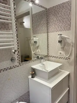 a bathroom with a white sink and a mirror at Eufonia Vatican Days in Rome