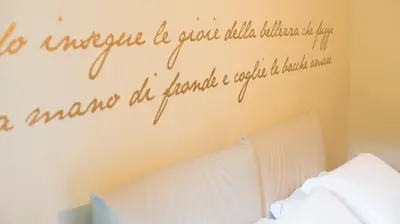 a bedroom with a bed with a quote on the wall at Domus Corsini in Rome