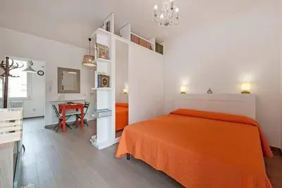 a bedroom with an orange bed and a table at L'Attichetto di Ponte Milvio a Roma Centro in Rome