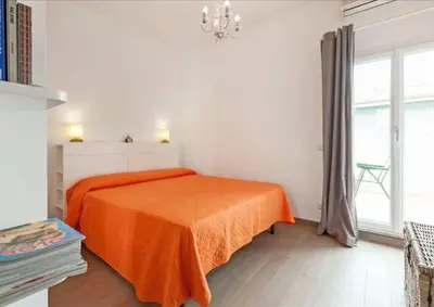 a bedroom with a bed with an orange blanket at L'Attichetto di Ponte Milvio a Roma Centro in Rome