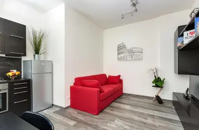a living room with a red couch and a refrigerator at Porta Latina Suite - Private Apartment Rome's Center in Rome