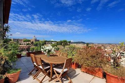 a wooden table and chairs on a balcony with a view at Sant'Onofrio Terrace Apartment in Rome