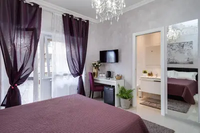 a bedroom with a bed and a desk and a mirror at Dreamsrome Suites in Rome