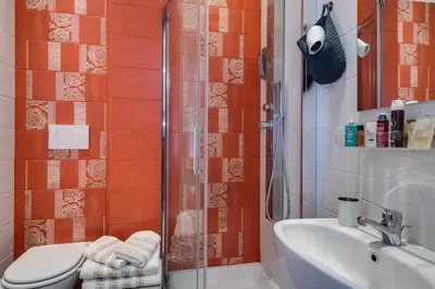 a bathroom with a shower and a toilet and a sink at Dreamsrome Suites in Rome