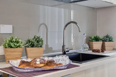 a kitchen counter with a plate of pastries in a sink at Dreamsrome Suites in Rome