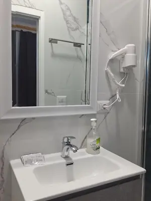 a bathroom sink with a mirror and a soap dispenser at Relax ON 247 in Rome