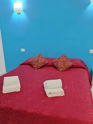 a red bed with towels on top of it at Relax ON 247 in Rome