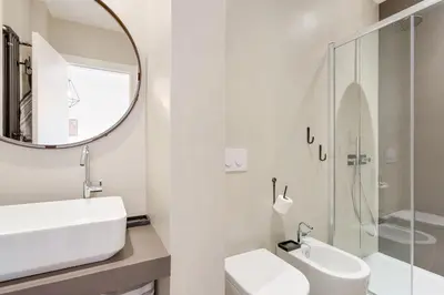a white bathroom with a sink and a mirror at Rome as you feel - Vatican Terrace Apartments with View in Rome