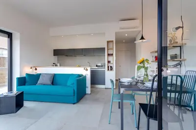 a living room with a blue couch and a table at Rome as you feel - Vatican Terrace Apartments with View in Rome