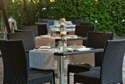 an outdoor table with chairs and a table set for dinner at LH Hotel Excel Roma Montemario in Rome