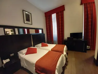 a hotel room with two beds with red pillows at LH Hotel Excel Roma Montemario in Rome