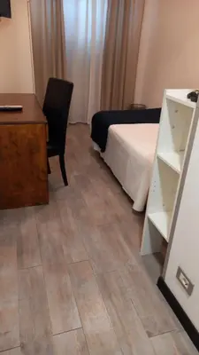 a bedroom with a bed and a desk and a chair at LH Hotel Excel Roma Montemario in Rome