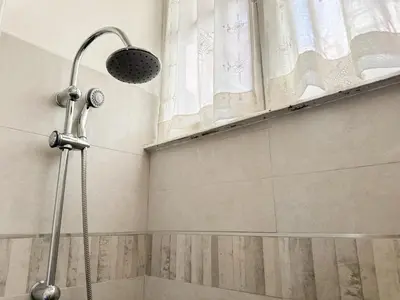 a shower with a shower head in a bathroom at Praetorian apartment in Rome