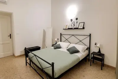 a bedroom with a bed with white sheets and pillows at Praetorian apartment in Rome