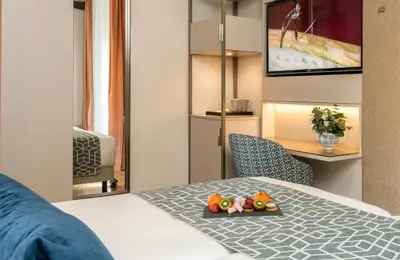 a hotel room with a bed and a table and a desk at Leonardo Boutique Hotel Rome Termini in Rome