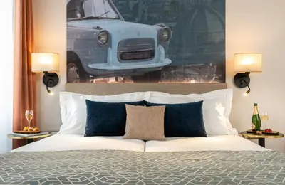 a bedroom with a bed with a picture of a car on the wall at Leonardo Boutique Hotel Rome Termini in Rome