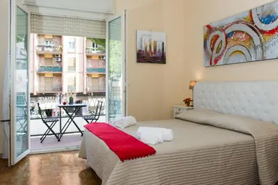 a bedroom with a bed and a view of a balcony at House Gregorio in Rome