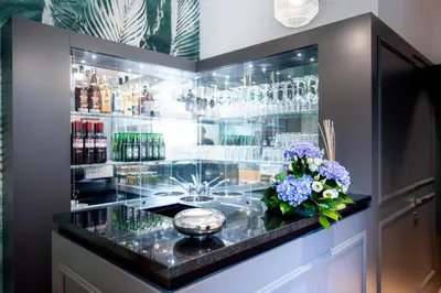 a bar with a counter with flowers and glasses at Boutique Centrale Palace Hotel in Rome