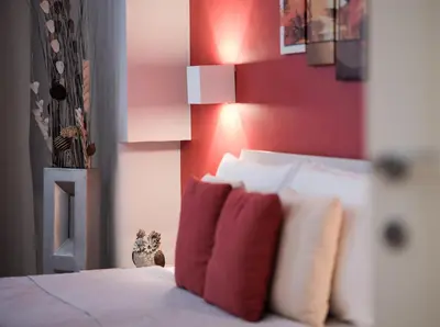 a bedroom with red walls and a bed with pillows at Roman Holidays House Marconi in Rome