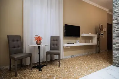 a room with a table and two chairs and a television at Roman Holidays House Marconi in Rome