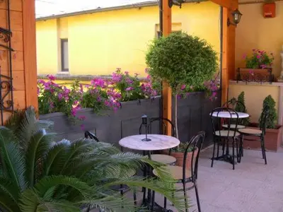 an outdoor patio with tables and chairs and flowers at Hotel Nardizzi Americana in Rome