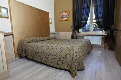 a bedroom with a bed and two windows at Hotel Nardizzi Americana in Rome