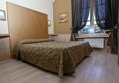 a bedroom with a bed in a room with a window at Hotel Nardizzi Americana in Rome