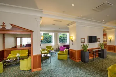 a lobby with yellow chairs and a waiting room at Grand Hotel Fleming by OMNIA hotels in Rome