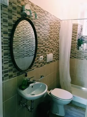 a bathroom with a sink and a toilet and a mirror at 4 You City Center Apartament in Rome