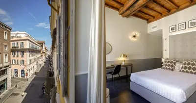 a bedroom with a bed and a view of a street at Stay Inn Rome Via Del Corso in Rome