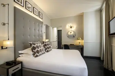 a bedroom with a large white bed and a desk at Stay Inn Rome Via Del Corso in Rome