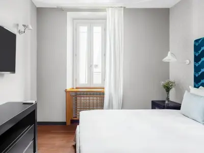 a bedroom with a white bed and a window at Numa Rome Vici in Rome