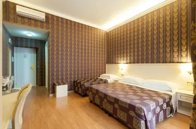 a hotel room with two beds and a table at Trevi 41 Hotel in Rome