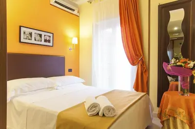 a hotel room with a bed with towels on it at Hotel Tuscolana in Rome