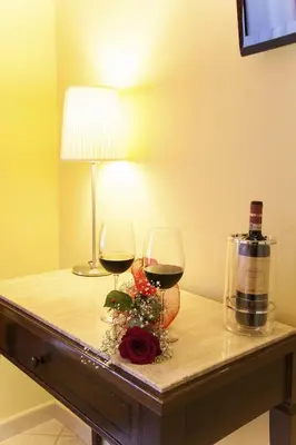 two glasses of wine and a lamp on a table at Hotel Tuscolana in Rome