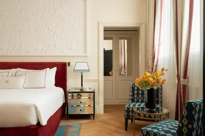 a bedroom with a bed and a chair and a table at Palazzo Ripetta in Rome