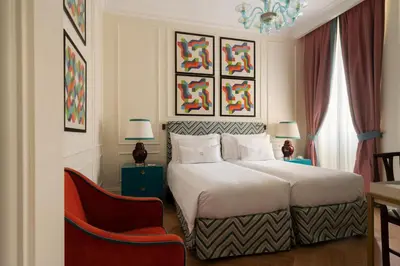 a bedroom with a large bed and a red chair at Palazzo Ripetta in Rome